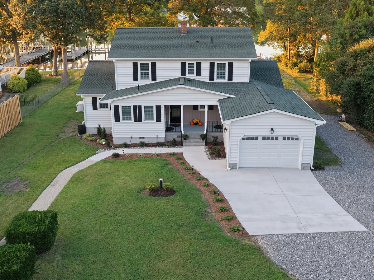 Golden-hour drone real estate photo of a renovated waterfront home and lot in Virginia
